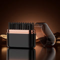 Black and rose gold hairbrush on a reflective surface with a dark background