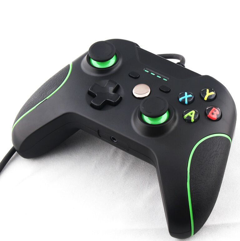 Black gaming controller with green accents on a white background