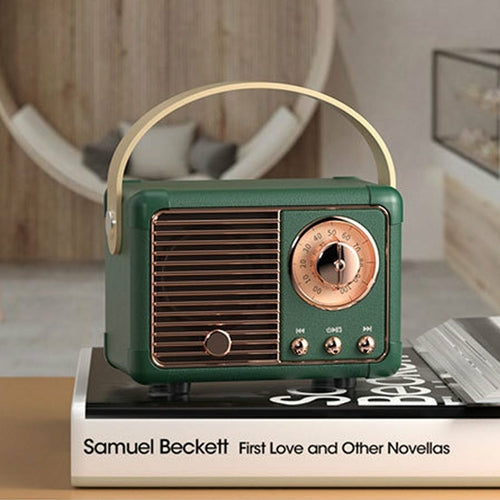 Vintage-style green radio on a book with a blurred indoor background