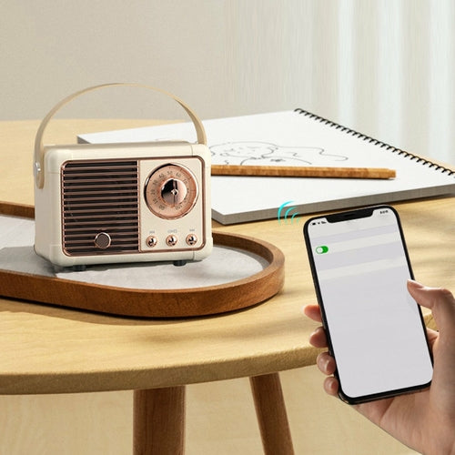 Vintage-style radio on a wooden table with a smartphone and notebook in the background