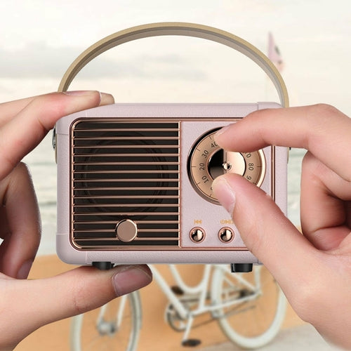 Person holding a vintage-style pink radio with a blurred bicycle in the background