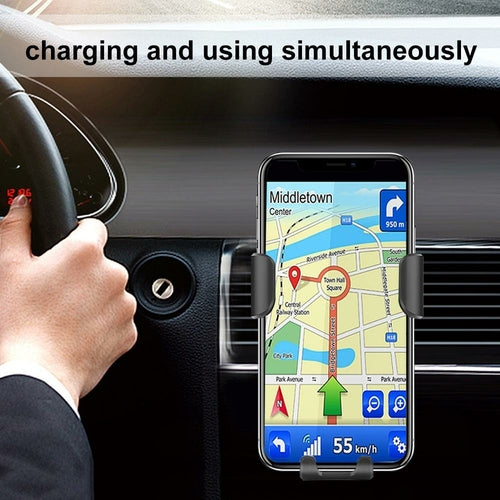 Phone mount on car dashboard with phone displaying navigation app, hand holding steering wheel.
