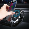 Hand holding a smartphone above a car air vent phone holder with wireless charging feature.
