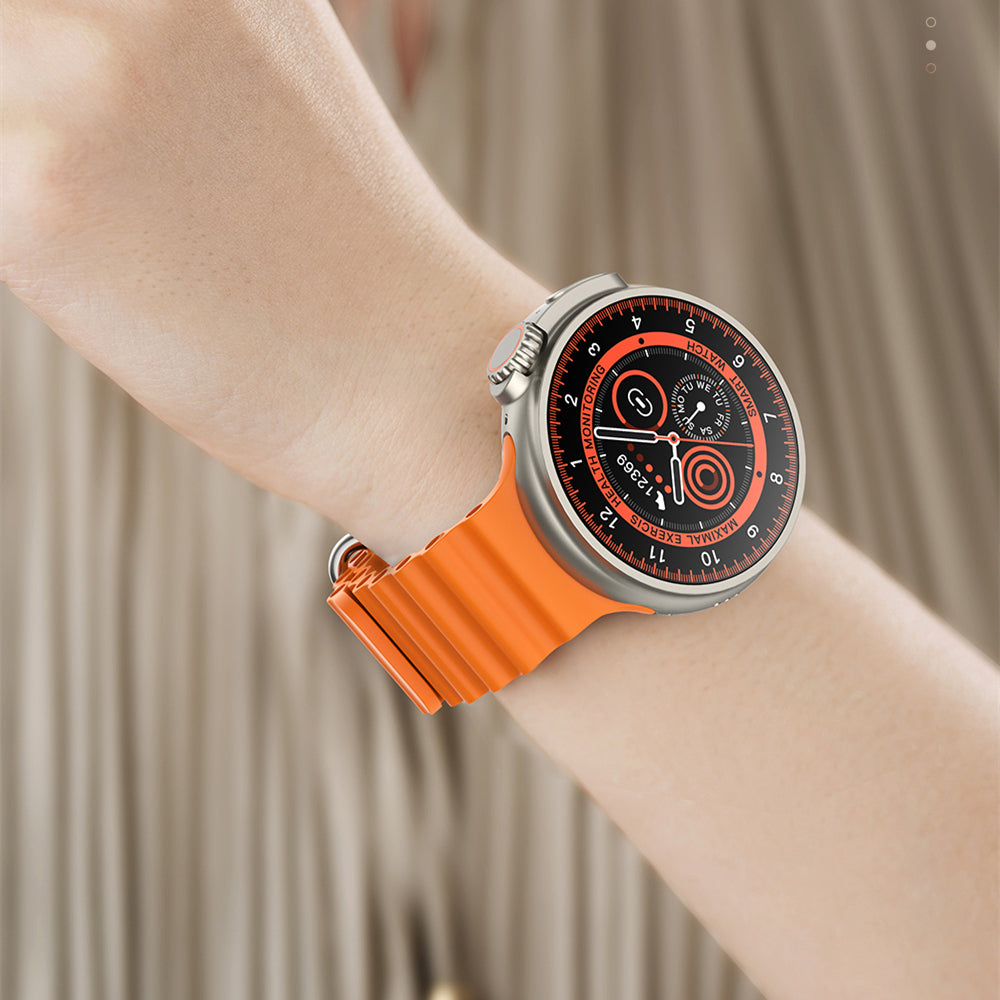 Wrist wearing a watch with an orange strap and black dial against a neutral background