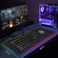 Gaming setup with monitor, keyboard, mouse, and desk pad on a dark surface.